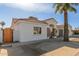 Front view of a remodeled home with a wood gate and stone accents at 9821 E University Dr, Mesa, AZ 85207