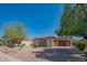 Front view of a home with a wooden garage door and landscaped yard at 9825 E Sharon Dr, Scottsdale, AZ 85260