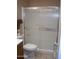 Bathroom featuring a toilet and shower with sleek sliding glass doors at 10731 W Mission Ln, Sun City, AZ 85351