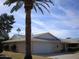 Tan one-story house with a white garage door and palm tree in the front at 10731 W Mission Ln, Sun City, AZ 85351