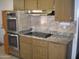 Kitchen with wood cabinets, granite countertops, and stainless steel appliances at 10731 W Mission Ln, Sun City, AZ 85351