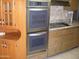 Stainless steel double oven built into wood cabinets in the kitchen at 10731 W Mission Ln, Sun City, AZ 85351