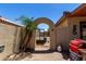 Backyard showing an arched entry, a small palm tree, and outdoor storage at 11346 E Renata Ave, Mesa, AZ 85212