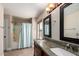 Bathroom featuring a dual sink vanity with granite counters and a shower-tub combo at 11346 E Renata Ave, Mesa, AZ 85212
