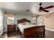 This main bedroom includes wood floors, a ceiling fan, and an ornate headboard at 11346 E Renata Ave, Mesa, AZ 85212