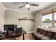This home office features a ceiling fan, desk, and a sofa with a window view at 11346 E Renata Ave, Mesa, AZ 85212