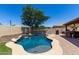 Backyard pool with rock waterfall feature, a built-in bar, and a patio BBQ area at 11346 E Renata Ave, Mesa, AZ 85212