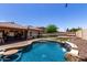 Backyard pool with waterfall feature, in-water table and seating, surrounded by manicured landscaping at 11346 E Renata Ave, Mesa, AZ 85212