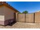This side yard features a wooden gate, and desert landscaping for easy maintenance at 11346 E Renata Ave, Mesa, AZ 85212