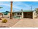 Tan single story home with teal accents, landscaped yard, and a palm tree at 1417 S Grand Dr, Apache Junction, AZ 85120