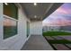 Covered patio with sunset view and artificial turf at 1447 S 239Th Dr, Buckeye, AZ 85326