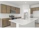 Modern kitchen featuring an island, stainless steel appliances, and ample cabinetry at 1559 S 239Th Dr, Buckeye, AZ 85326