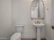 Stylish powder room with pedestal sink and patterned flooring at 16637 W La Reata Ave, Goodyear, AZ 85395