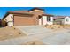 New construction home with a tan exterior and a two-car garage at 18398 W Monte Lindo Ln, Surprise, AZ 85387