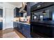 Modern kitchen with dark blue cabinetry, gas range, and stainless steel appliances at 19087 E Walnut Ct, Queen Creek, AZ 85142