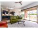Open living room with green couch and view of kitchen and backyard at 19087 E Walnut Ct, Queen Creek, AZ 85142