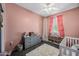 bedroom with pink walls, a crib, and plenty of storage at 24310 N Sickle Rd, Florence, AZ 85132