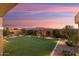 Backyard with artificial turf, mountain views, and colorful sunset at 27453 W Wahalla Ln, Buckeye, AZ 85396