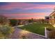Backyard with artificial turf, mountain views, and sunset at 27453 W Wahalla Ln, Buckeye, AZ 85396