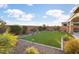 Landscaped backyard with artificial turf and mountain views at 27453 W Wahalla Ln, Buckeye, AZ 85396