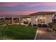 Backyard patio at sunset with artificial turf and covered patio at 27453 W Wahalla Ln, Buckeye, AZ 85396