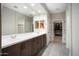 Double vanity bathroom with large mirror and walk-in closet access at 27453 W Wahalla Ln, Buckeye, AZ 85396