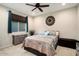 Bedroom with ceiling fan, window, and southwestern decor at 27453 W Wahalla Ln, Buckeye, AZ 85396