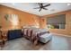 Spacious bedroom with southwestern decor, ceiling fan and large window at 27453 W Wahalla Ln, Buckeye, AZ 85396