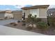 House exterior with landscaped front yard, drought-resistant plants, and driveway at 27453 W Wahalla Ln, Buckeye, AZ 85396