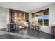 Wet bar with stone feature wall, wine cooler, shelving, and seating area at 27453 W Wahalla Ln, Buckeye, AZ 85396