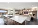 Open kitchen with large island, stainless steel appliances, and view to living room at 27453 W Wahalla Ln, Buckeye, AZ 85396
