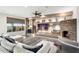 Spacious living area with a large sectional sofa and a stone fireplace at 27453 W Wahalla Ln, Buckeye, AZ 85396