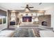 Spacious living room featuring a stone fireplace and built-in shelving at 27453 W Wahalla Ln, Buckeye, AZ 85396