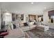 Open living area with large sectional sofa, stone fireplace, and built-in entertainment center at 27453 W Wahalla Ln, Buckeye, AZ 85396