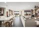 Open concept living room and kitchen with large sectional sofa and stone fireplace at 27453 W Wahalla Ln, Buckeye, AZ 85396