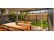 Outdoor patio with wood dining table and chairs, lush green landscaping at 2937 E Osborn Rd, Phoenix, AZ 85016