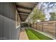 Side yard with a walkway, artificial turf, and a modern fence at 2937 E Osborn Rd, Phoenix, AZ 85016