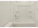 Clean white bathroom featuring a bathtub with shower head and built in shelves at 37073 W La Paz St, Maricopa, AZ 85138
