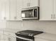Kitchen with gas range, quartz counters, stainless appliances and white backsplash at 37073 W La Paz St, Maricopa, AZ 85138