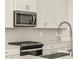 Close-up of kitchen featuring stainless steel appliances, gas range, and gray backsplash at 37073 W La Paz St, Maricopa, AZ 85138