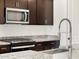 Close up of stainless steel microwave and range with granite countertop and wood cabinets at 37358 W San Clemente St, Maricopa, AZ 85138