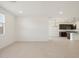 Open-concept living area with tile flooring and an adjoining kitchen featuring dark cabinets at 37358 W San Clemente St, Maricopa, AZ 85138