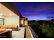 Evening view of a large covered patio with seating and a fireplace at 37956 N School House Rd, Cave Creek, AZ 85331