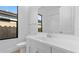 Modern bathroom featuring white cabinets, large mirror, a window, and tile backsplash in shower at 42104 N Golden Trl, San Tan Valley, AZ 85140