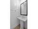 Clean powder room featuring a pedestal sink, black framed mirror, and modern fixtures at 42104 N Golden Trl, San Tan Valley, AZ 85140
