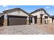 Attractive single-story home featuring stone accents, a paver driveway, and a low-maintenance desert landscape at 42104 N Golden Trl, San Tan Valley, AZ 85140