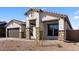 Single-story stucco home featuring stone accents, a brown roof, and a well-manicured, low-maintenance front yard at 42104 N Golden Trl, San Tan Valley, AZ 85140