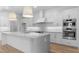 Bright, modern kitchen with white cabinetry, a large island, stainless steel appliances, and pendant lighting at 42104 N Golden Trl, San Tan Valley, AZ 85140