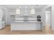 Modern kitchen featuring a large island, white cabinets, stainless steel appliances, and sleek lighting at 42104 N Golden Trl, San Tan Valley, AZ 85140