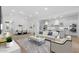 Bright living room with white decor, modern furnishings, and open floor plan to kitchen and dining area at 42104 N Golden Trl, San Tan Valley, AZ 85140